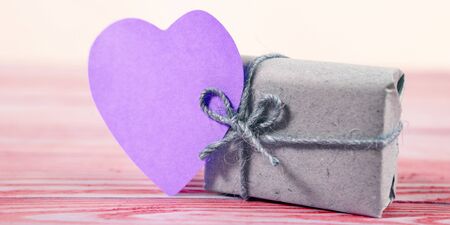 Gift boxes wrapped kraft paper tied with twine and sticker heart and tied with twine. with copy spaceの写真素材