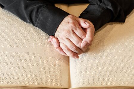 close up view of woman reading braille text on old bookの写真素材