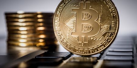 New virtual money Golden bitcoin coin on a black keyboard. Cryptocurrency. Business and Trading concept.の写真素材