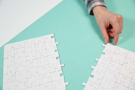Hands assembling jigsaw puzzle, to find common solution concept