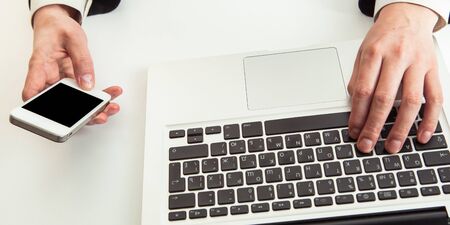 Man hand on laptop keyboard with blank screen monitorの写真素材