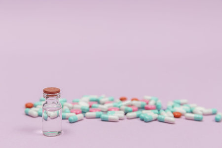 Pill and injection bottle on pink background