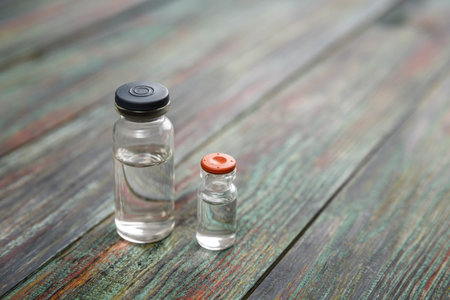 Injection bottle on wooden background with copy space