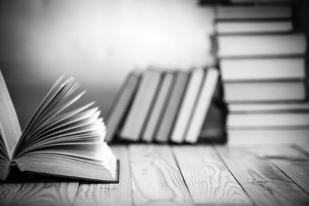 Open textbooks on wood desk with blurred focus for education background. Back to school concept