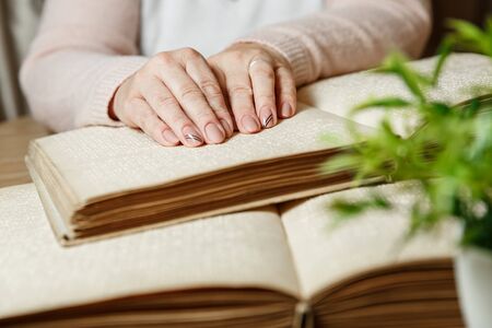 close up view of woman reading braille text on old bookの写真素材