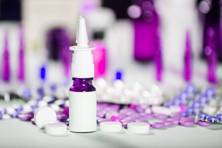 Spray for the nose or a pill to treat colds and gripes glass bottle with medicines. Pharmaceutical medication and medicine pills in packsの写真素材