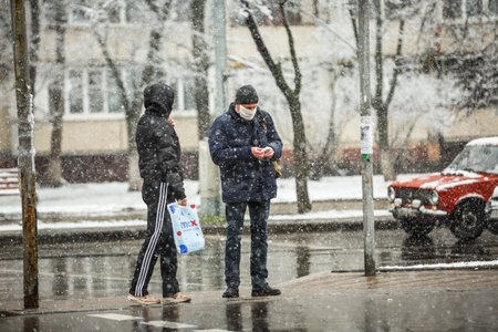 KYIV, UKRAINE - MARCH 22: People wear face masks during snowfall March 22, 2020 in Kyiv, Ukraine.