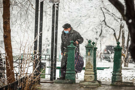 KYIV, UKRAINE - MARCH 22: A man wearing a protective mask as a precaution against the outbreak of Coronavirus during snowfall March 22, 2020 in Kyiv, Ukraine.のeditorial素材