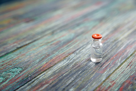 Injection bottle on wooden background