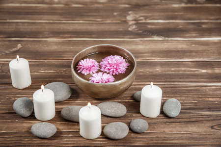 Singing bowl with candles with pebbles on dark wooden backgroundの写真素材