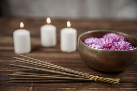 Singing bowl with candles with pebbles on dark wooden backgroundの写真素材