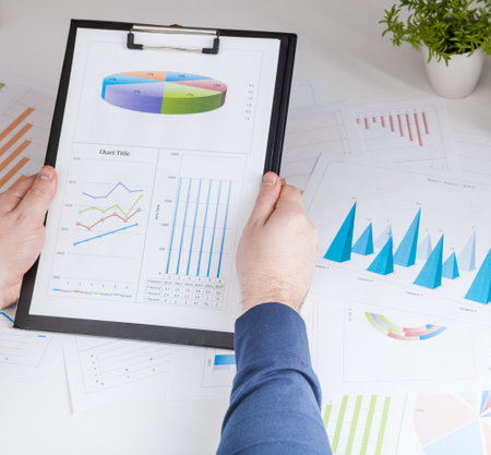 Closeup of a man checking accounts. Stock market chart and finger pointing on tablet in office.の写真素材