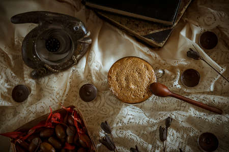 Cup of hot coffee with foam and old books on a vintage background with autumn elementsの写真素材