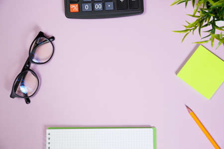 Office supplies in the pink workspace. Top view with copy space for input the text. Designer workspace on desk table essential elements on flat layの写真素材