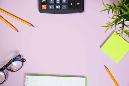 Office supplies in the pink workspace. Top view with copy space for input the text. Designer workspace on desk table essential elements on flat layの写真素材