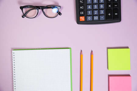 Office supplies in the pink workspace. Top view with copy space for input the text. Designer workspace on desk table essential elements on flat layの写真素材