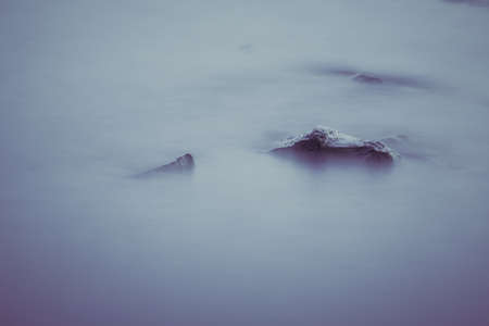 Beautiful stream flowing in motion. Natural background. Toning an imageの写真素材