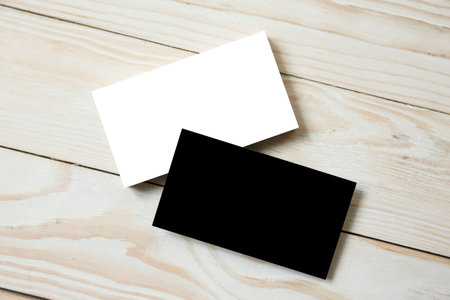 Business cards blank. White and black mockup on wooden background. Flat Lay. copy space for textの写真素材
