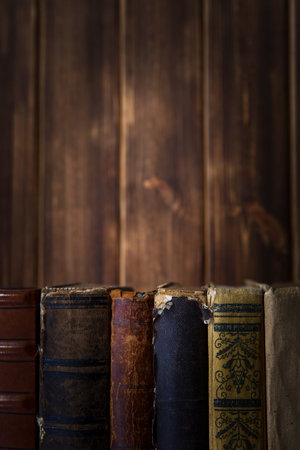 Old books on wooden shelf. Bookshelf history theme grunge background.の写真素材