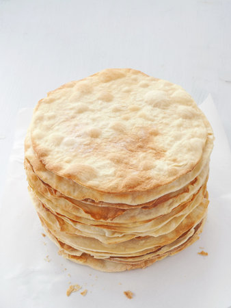 Cooking process. Preparing multi-layered cake. Crusts for homemade mille feuille. Big pile of fresh...