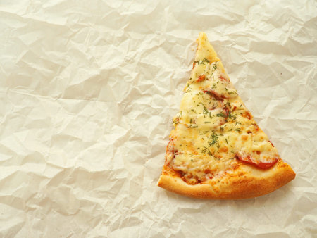 Piece of freshly made pepperoni pizza upon baking parchment. Culinary background. Homemade pizza...