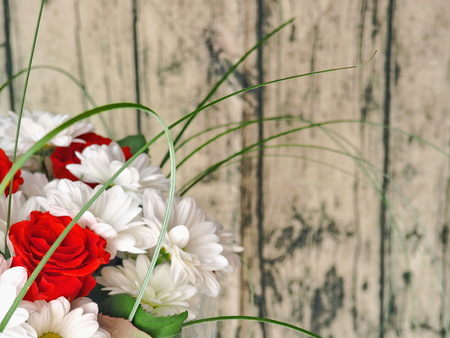 Flower background, blur. Bouquet of white chrysanthemum and red roses arranged on vintage wooden table. Selective focus on the front. Copy space for your text.の写真素材