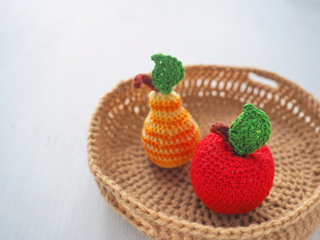 Crochet fruits in a basket close up. Knitted toys. Selective focus. Copy space for your text.の写真素材
