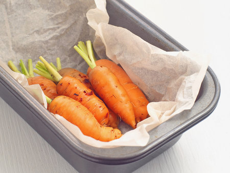 Glazed baby carrot in a pan. Baked carrots with herbs. Selective focus.の写真素材