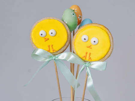 Two easter sugar cookies decorated as easter chicks. Hand held cookies. Ester treat. Funny little chickens as Easter decoration. Selective focus.の写真素材