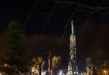 Monument of freedom. woman holding three gold stars which symbolise three regions of Latvia. Night celebrationのeditorial素材