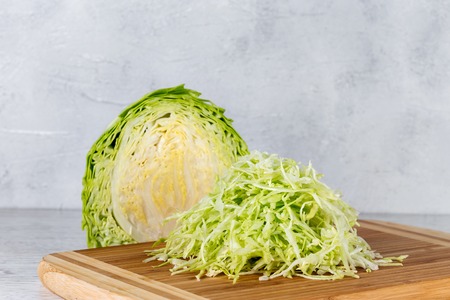 Fresh green cabbage on a yellow cutting boardの写真素材