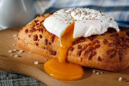 Poached egg on a slice of bread on a wooden surface