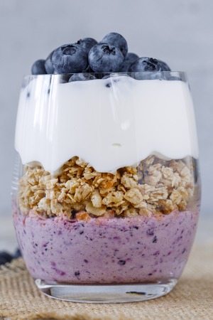 Granola with yogurt and blueberriesGranola with yogurt and blueberries in a glass beakerの写真素材
