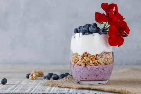 Granola with yogurt and blueberriesGranola with yogurt and blueberries in a glass beakerの写真素材