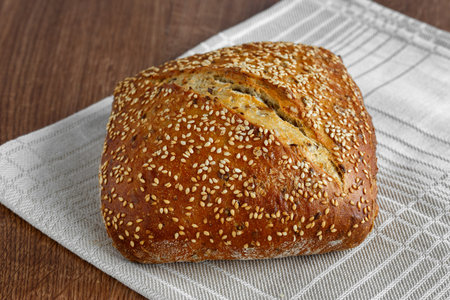 Bread loaf with sesame seeds on a linen napkin
