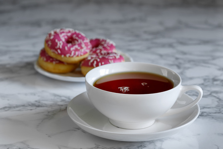 A cup of tea and a saucer with donuts , breakfast timeの写真素材