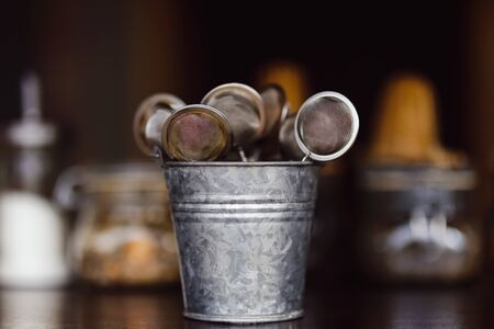 Tea strainers in a zinc bucket on a bar counterの写真素材