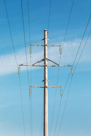 Electricity pylon silhouetted against blue sky background. High voltage tower.の写真素材