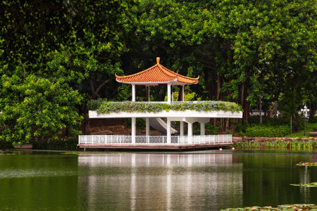 A pagoda pavilion on the shore of a pond in a park in Shenzhen, China, 07/18/2024の写真素材