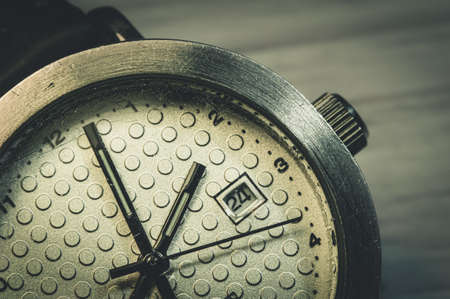 An old wristwatch with a scratched glass close-upの写真素材