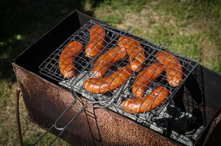 Hot fried sausages in the grill. Cooking on charcoal in the grill.の写真素材