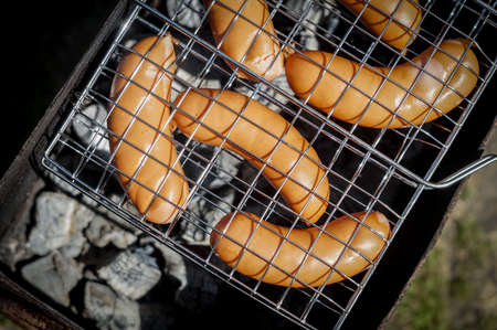 Hot fried sausages in the grill. Cooking on charcoal in the grill.の写真素材