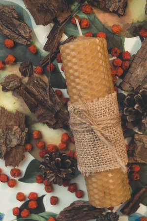 Wax candle handmade close-up. Festive decor of berries and bark.の写真素材