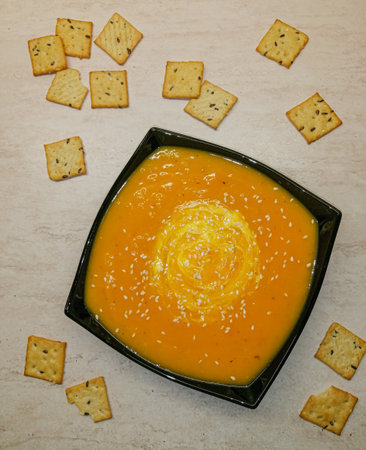 Top view of a plate of pumpkin soup mashed, with sour cream and crackers.の写真素材