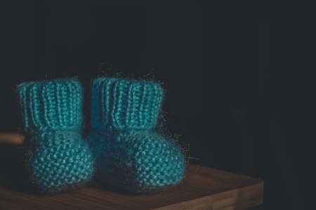 A pair of blue booties for a small child. Early morning, light from the window.の写真素材