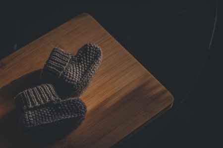 A pair of gray booties for a small child. Early morning, light from the window.の写真素材