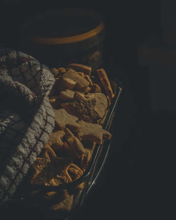 Homemade ginger cookies close-up under the kitchen towel in a glass bowl. Early morning, light from the window. Flat layの写真素材