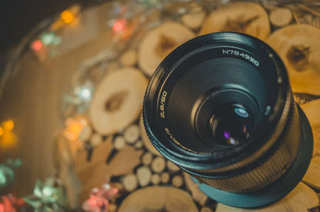 Soviet old lens with manual focus on a decorative wooden stand. Warm light.の写真素材