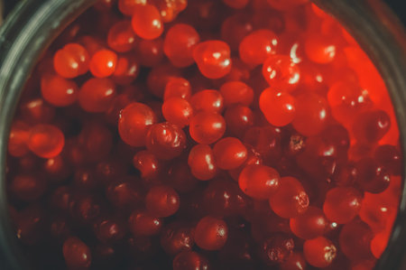 Close up harvest of berries in glass jars. Stone berry, kostyanika, rubus saxatilis. Rustic style,...