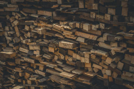 Sawn wood stacked in stacks. Harvesting firewood for winter. Wood fuel for the stove. Selective focus.の写真素材